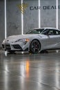 Vertical shot of a white Toyota Supra A90 MK5 front view with the left headlight on