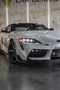 Vertical shot of a white Toyota Supra A90 MK5 front view with the right headlight on