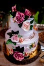Vertical shot of a white wedding cake  decorated with colorful flowers Royalty Free Stock Photo