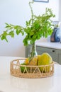 Vertical shot of a wicker container with a vase of plants and fruits