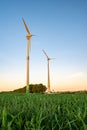 Vertical shot of wind turbines in green grass field Royalty Free Stock Photo