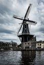 Vertical shot of a windmill in Haarlem reflected on the water under the cloudy sky, The Netherlands Royalty Free Stock Photo