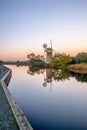 Vertical shot of a windmill reflected on the water during the sunset in How Hill, Norfolk Royalty Free Stock Photo