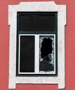 Vertical shot of a window with broken glass on a red building Royalty Free Stock Photo