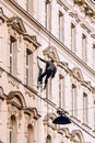 Vertical shot of a window washer washing the windows of an old style building Royalty Free Stock Photo