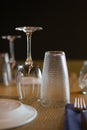 Vertical shot of a wine glass and a juice glass upside down on a restaurant table Royalty Free Stock Photo