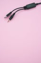 Vertical shot of a wire with a USB end and audio cable on a pink background Royalty Free Stock Photo