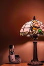 Vertical shot of a wireless black telephone with cradle and a glowing lamp on the table Royalty Free Stock Photo