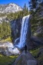 Vertical shot of a woman hiking in the Vernal Falls waterfall of Yosemite National Park in the USA Royalty Free Stock Photo