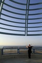 Vertical shot of a woman standing under a circular metal construction