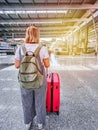 Vertical shot of a woman in a train station with luggage and backpack ready to travel Royalty Free Stock Photo