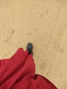 Vertical shot of a woman wearing a red skit and black boots walking on the sandy beach, top view Royalty Free Stock Photo