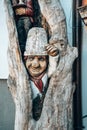 Vertical shot of wood carving, a funny gnom in a tree