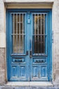 Vertical shot of a wooden blue door on the cement wall of an old building Royalty Free Stock Photo