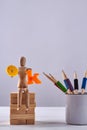 Vertical shot of wooden mannequin and cup of pencils. Royalty Free Stock Photo