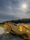 Vertical shot of a wooden off-road toy truck on a rock surface against bright sun background Royalty Free Stock Photo