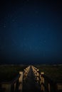 Vertical shot of a wooden path under the amazing Milky Way over Holden Beach, North Carolina