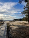 Vertical shot of wooden pathway on the beach and sea with blue cloudy sky in the background Royalty Free Stock Photo