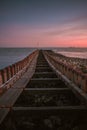 Vertical shot of a wooden pier over the sea captured at sunset in Vlissingen, Netherlands Royalty Free Stock Photo