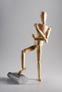 Vertical shot of a wooden pose doll with one foots stepped up and crossed arms