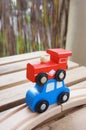 Vertical shot of a wooden red toy train on a blue toy car Royalty Free Stock Photo