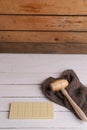 Vertical shot of a wooden small mallet near a bar of white chocolate