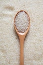 Vertical shot of a wooden spoon of rice on a rice texture Royalty Free Stock Photo