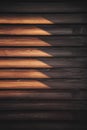 Vertical shot of a wooden wall panel illuminated by a stream of golden sunlight.