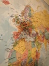 Vertical shot of a world map on a wall with colorful pins attached on the Europe continent