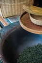 Vertical shot of woven baskets, broom and dried tea leaves in a bowl