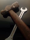 Vertical shot of a wrench and old hammer with a wooden handle on a black background Royalty Free Stock Photo
