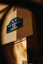 Vertical shot of the "Le Soleil de Paris" street sign on a yellow wall Royalty Free Stock Photo