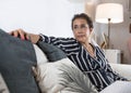 Vertical shot of a 50-year-old cancer overcomer sitting on the sofa Royalty Free Stock Photo