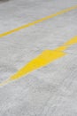 Vertical shot of a yellow arrow street sign on asphalt Royalty Free Stock Photo