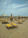 Vertical shot of yellow and blue umbrellas and chairs on a beach during daylight