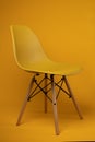 Vertical shot of yellow Eames chair isolated on yellow background Royalty Free Stock Photo