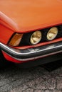 Vertical shot of the yellow headlights of an orange classic retro BMW 320  car Royalty Free Stock Photo