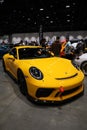 Vertical shot of a yellow Porsche Car in the car show