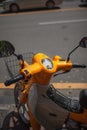 Vertical shot of a yellow scooter parked on the street Royalty Free Stock Photo