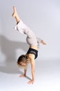 Vertical shot of a young Caucasian dancer in a studio photo session doing a handstand Royalty Free Stock Photo