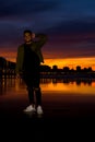 Vertical shot of a young female posing on a beautiful sunset background Royalty Free Stock Photo