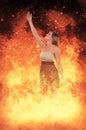 Vertical shot of a young female reaching up surrounded by flames