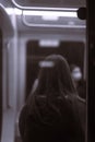 Vertical shot of a young girl standing inside a subway car Royalty Free Stock Photo