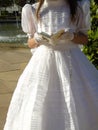 Young girl in white dress and gloves holding Holy Bible and rosary beads in the street Royalty Free Stock Photo