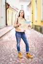 Vertical shot of young happy woman holding map.