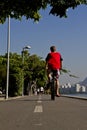 Vertical shot of a young male cycling on Rio de Janeiro's coastline boulevard