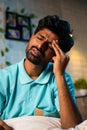 Vertical shot of young man suffering headache pain during night at home - concept of tension, health problems and Royalty Free Stock Photo