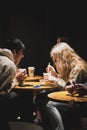 Vertical shot of young people sitting in the Starbucks cafe drinking coffee in Auckland, New Zealand