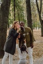 Vertical shot of a young woman blowing soap bubbles in a park with her husband and child Royalty Free Stock Photo