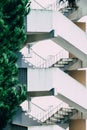 Vertical shot of zigzagging white stairs with weathered walls